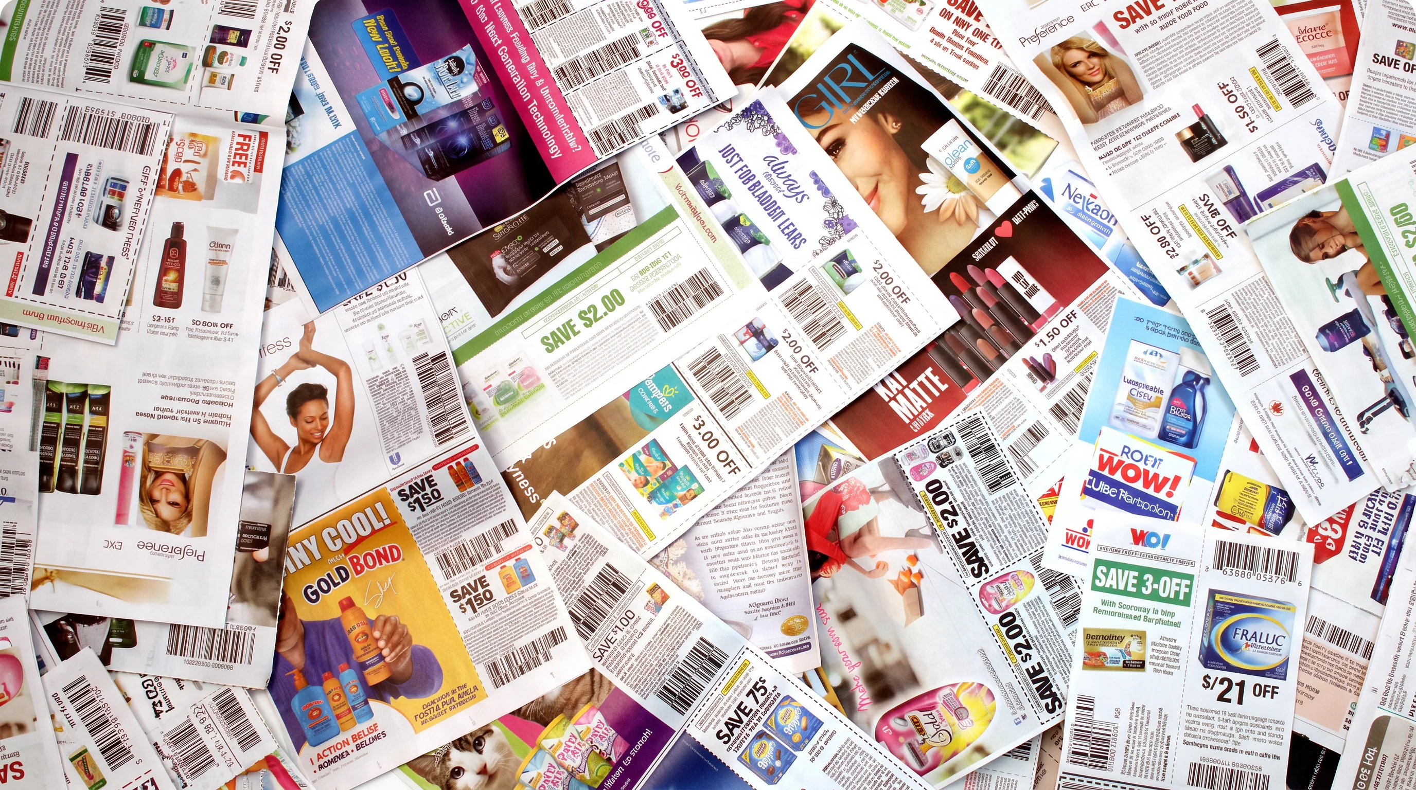 Assorted printed retail coupons spread across a surface.